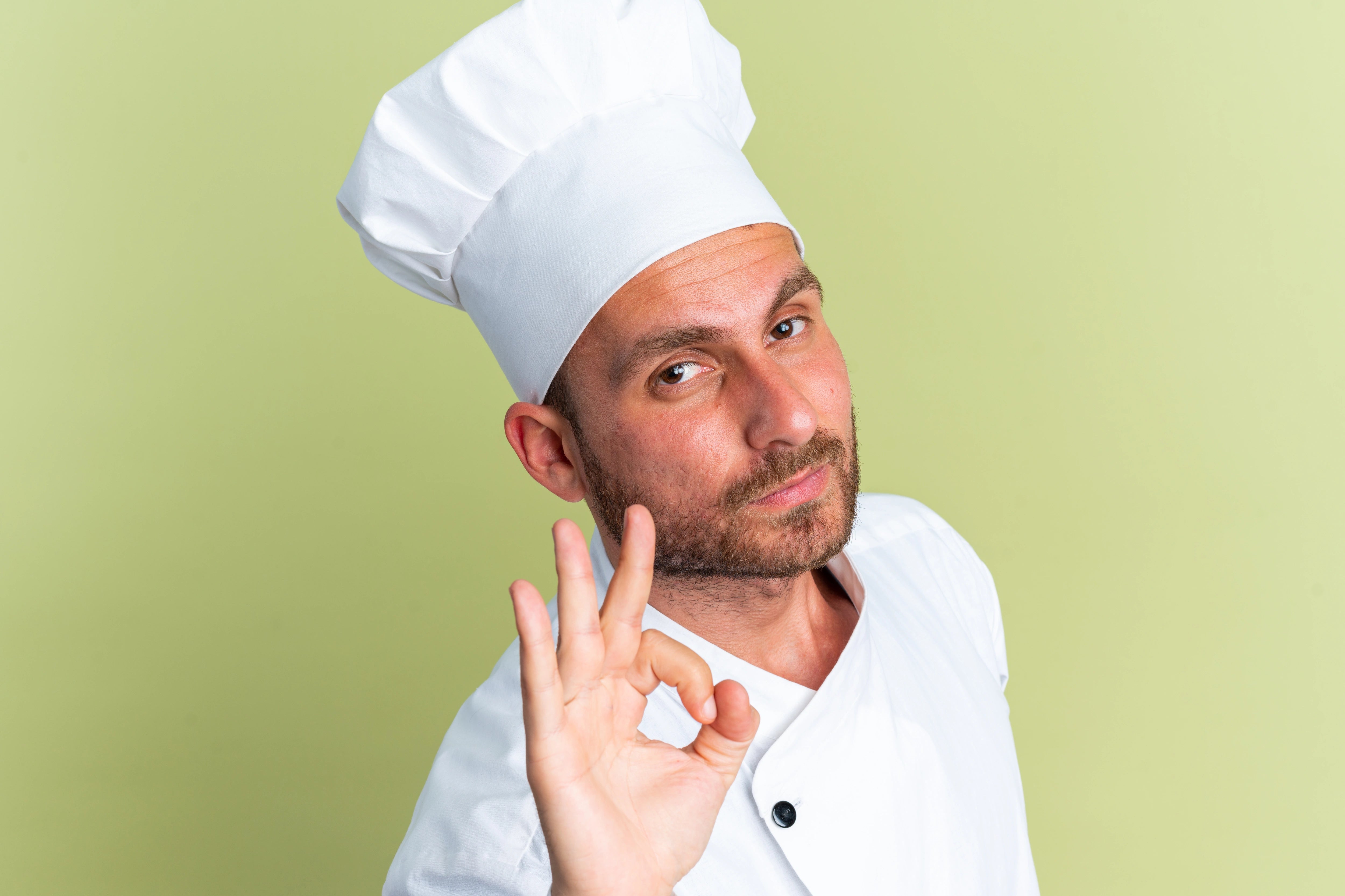 Mann mit Kochmütze blickt in die Kamera.