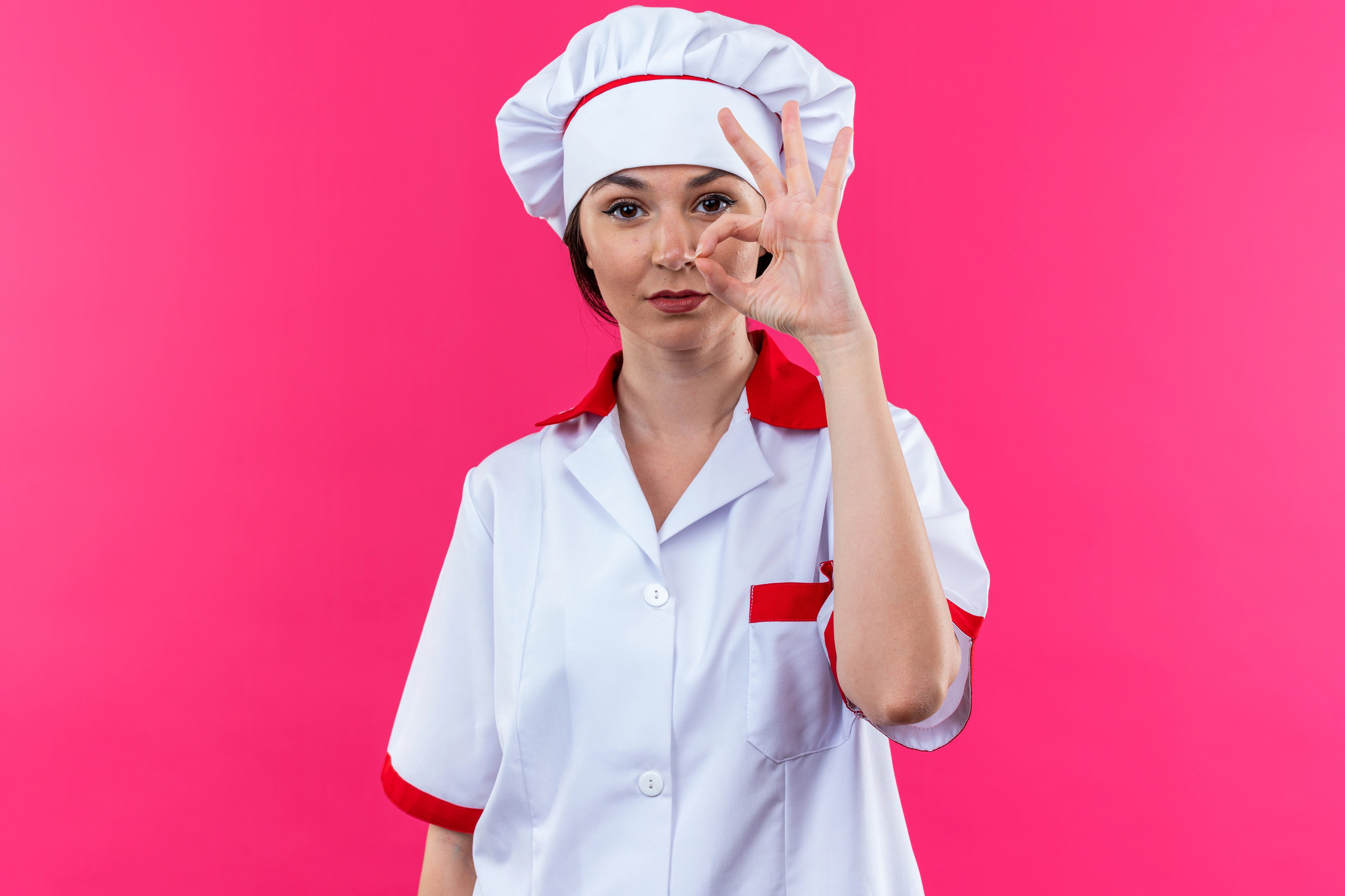 Junge Köchin blickt zufrieden in die Kamera.