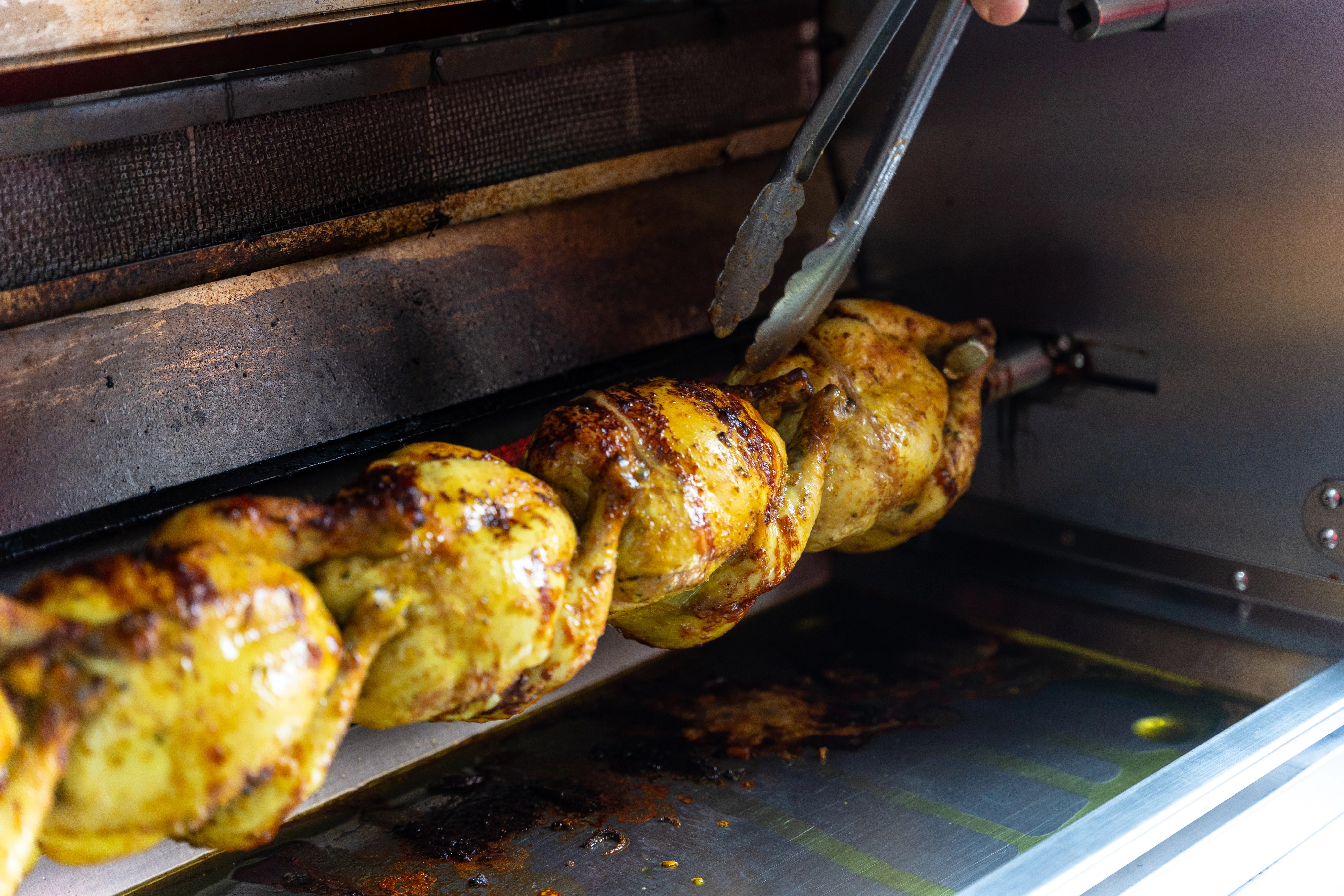 Gegrillte Hähnchen auf einem Grillspieß.