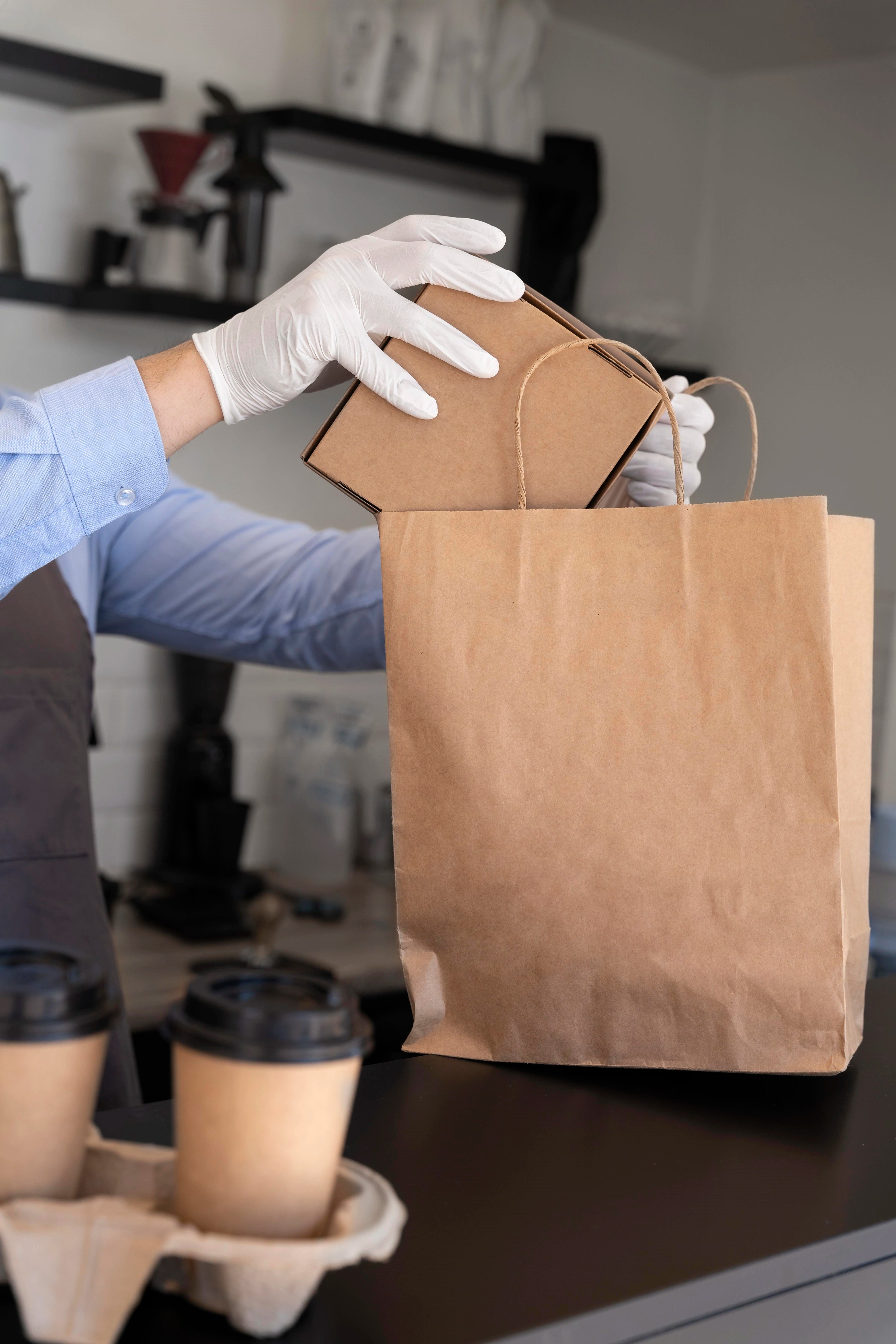 Gastronom füllt gerade Take-Away-Gerichte in eine Tragetasche.
