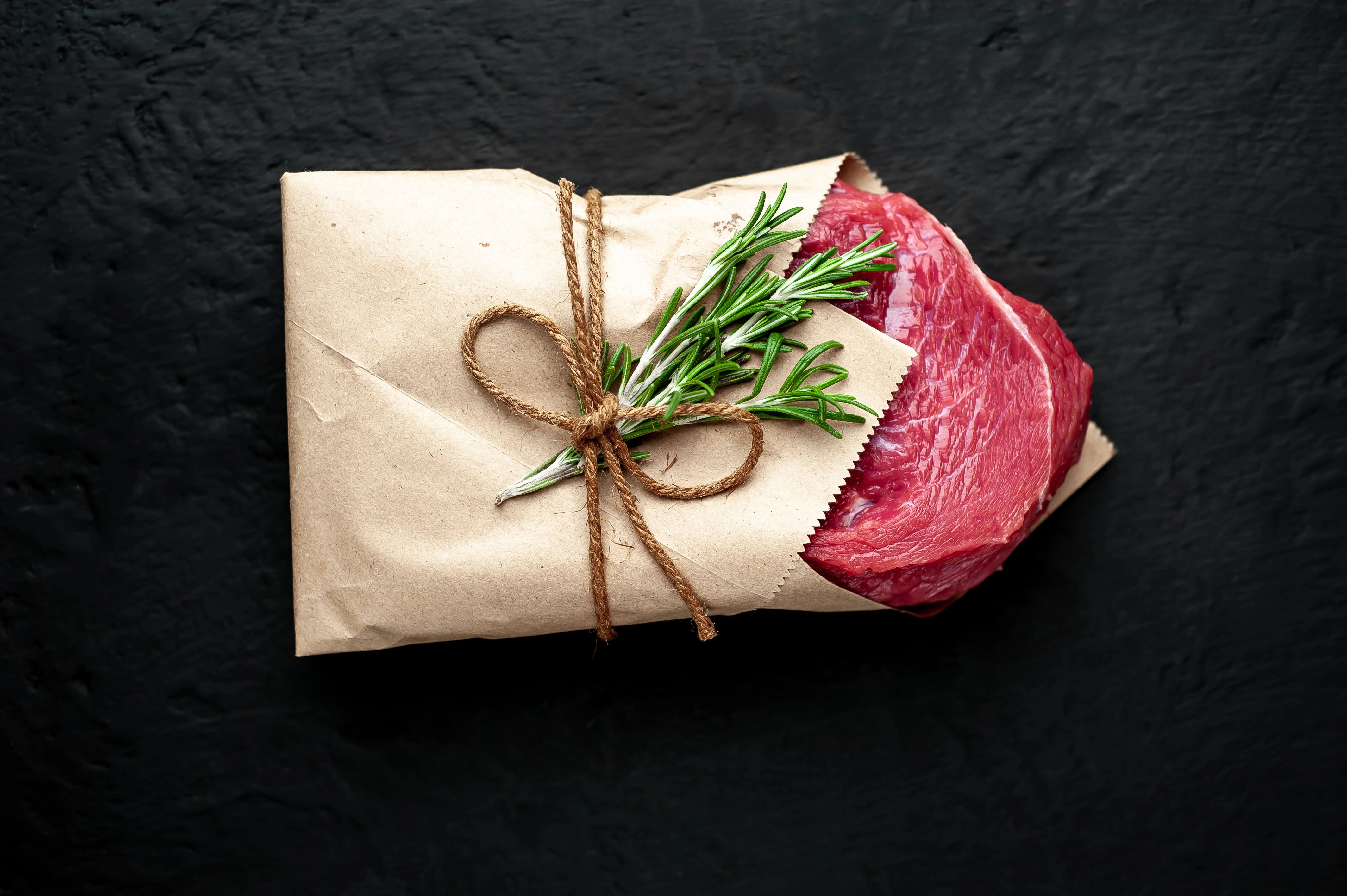 Stück Fleisch, das in einem Metzgerfaltenbeutel eingepackt ist.