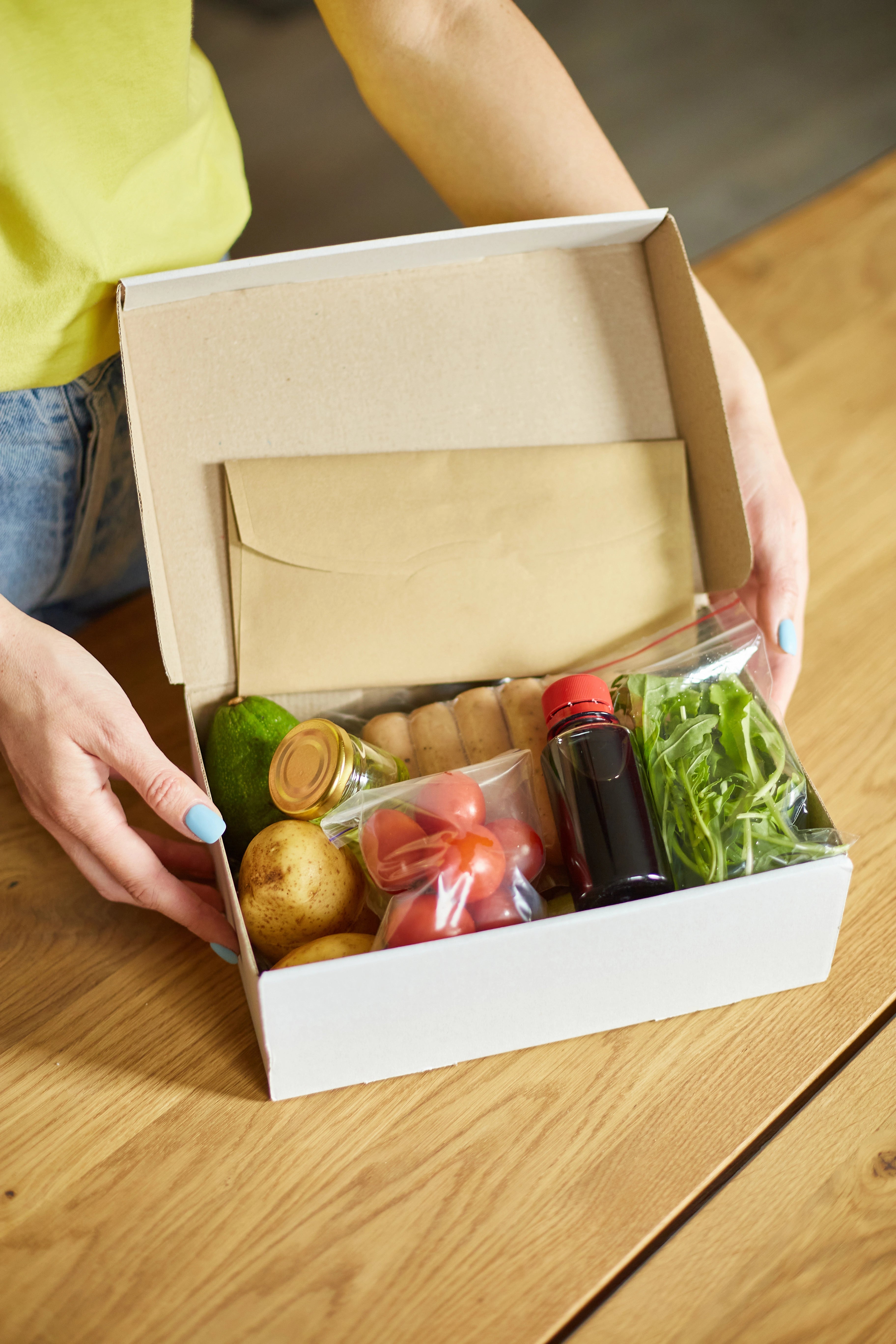Vorgefertige Speisen und Getränke in einer braunen Transportbox.