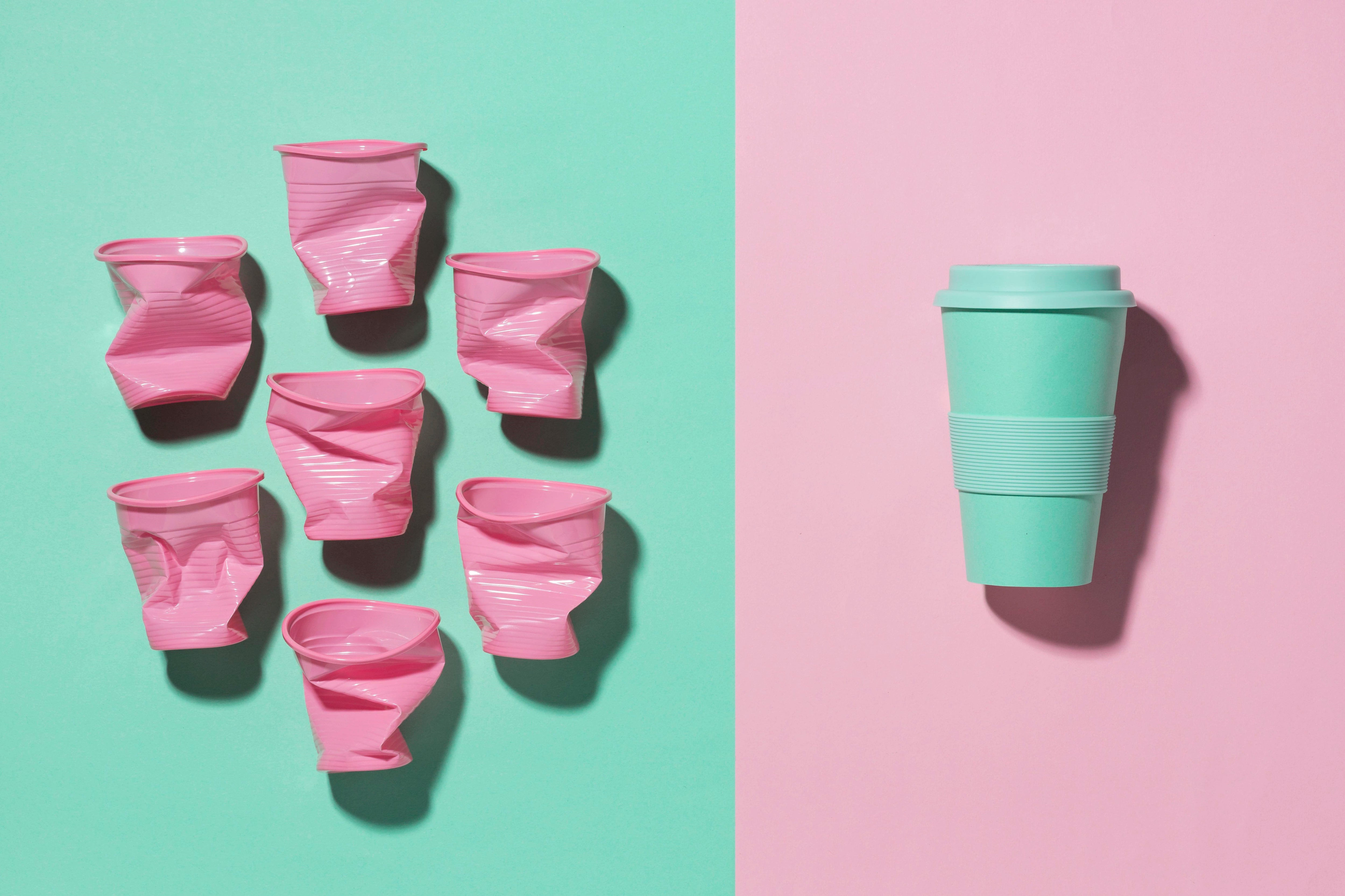 Mehrweg-Trinkbecher neben weniger umweltfreundlichen Einwegbechern.