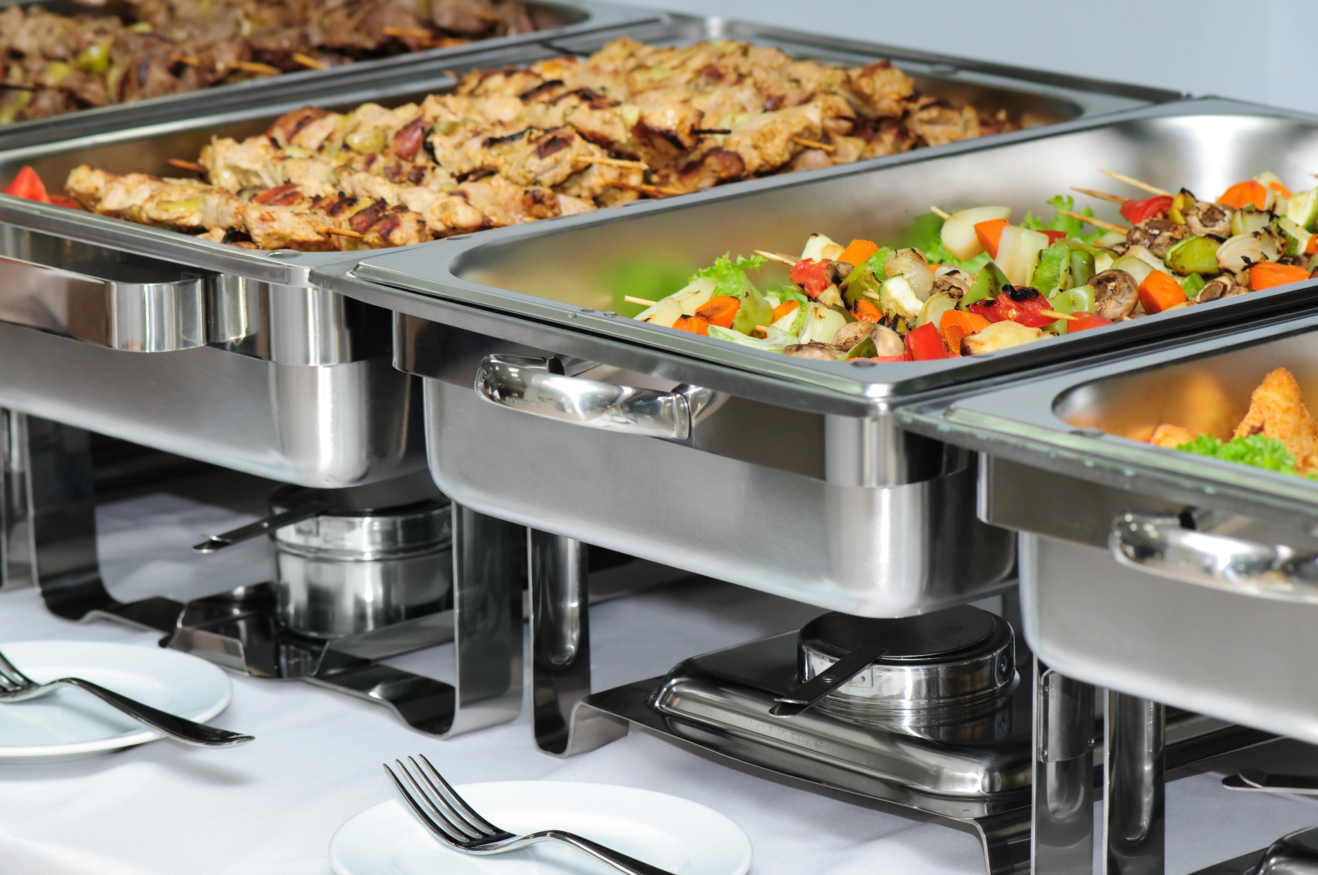Buffet-Tisch mit Brenngel unter den einzelnen Wärmebehältern.