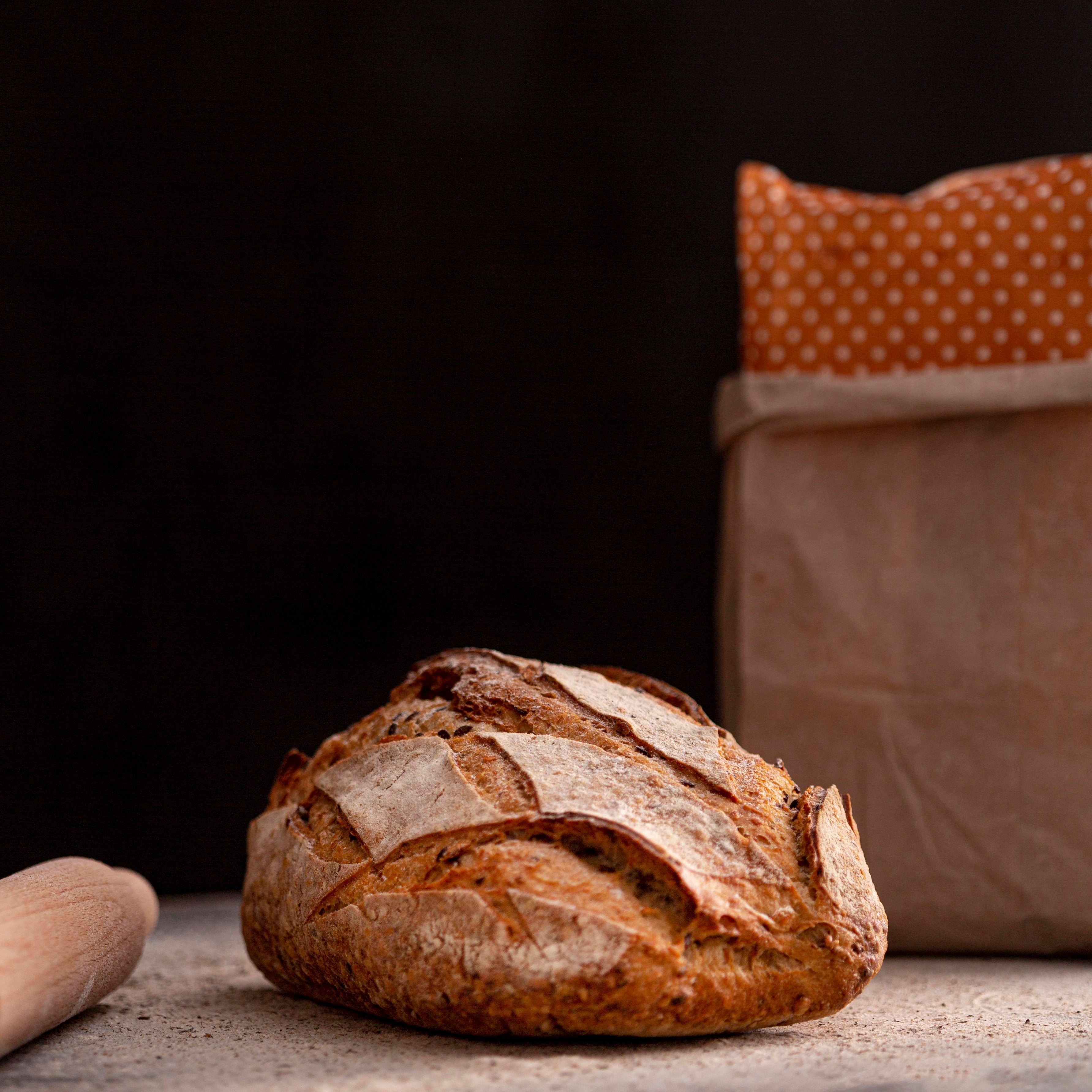 Leckeres, knuspriges, frisches Brot vor eine Bäckertüte.