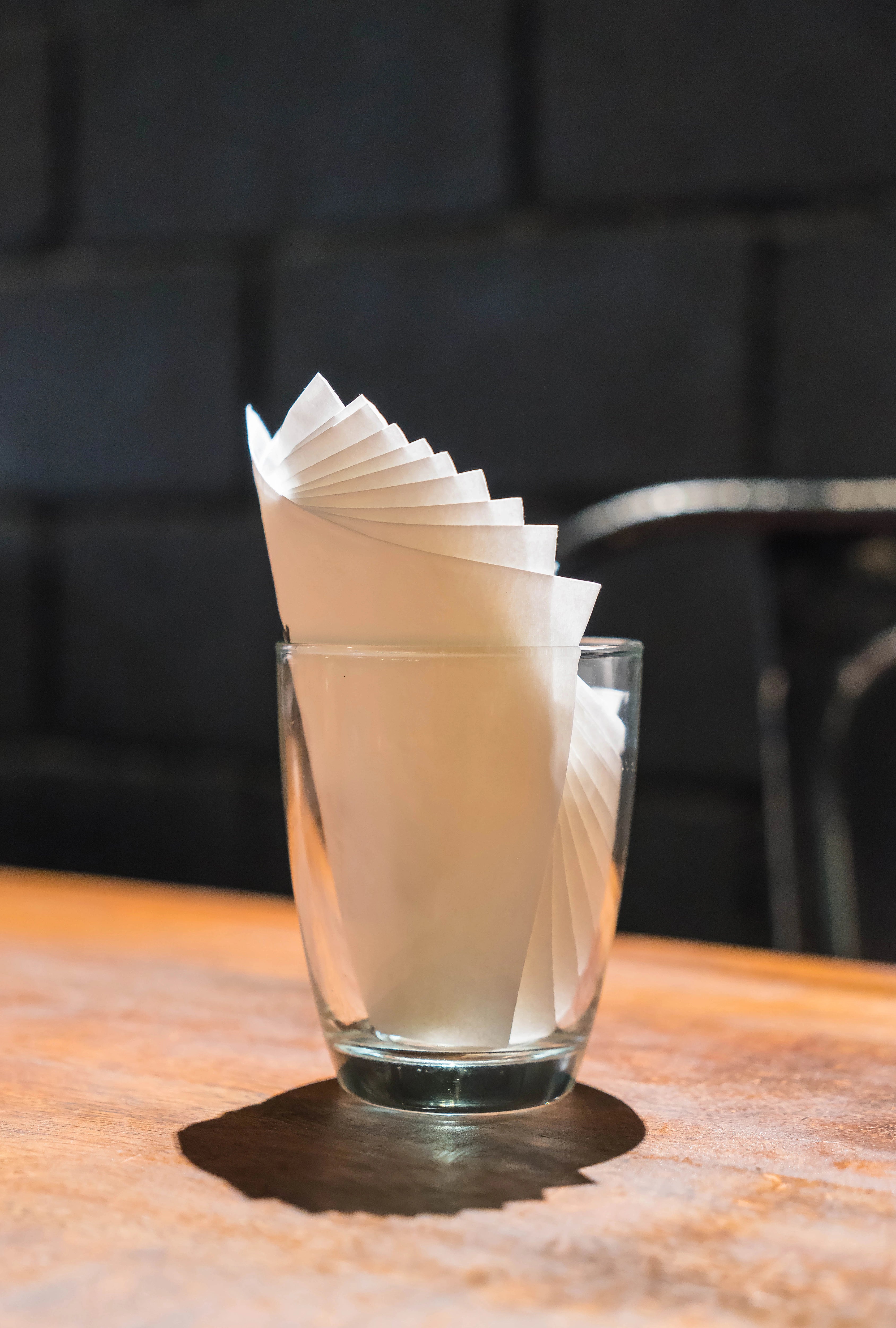 Weiße Servietten Airlaid, dekorativ in einem Glas präsentiert.