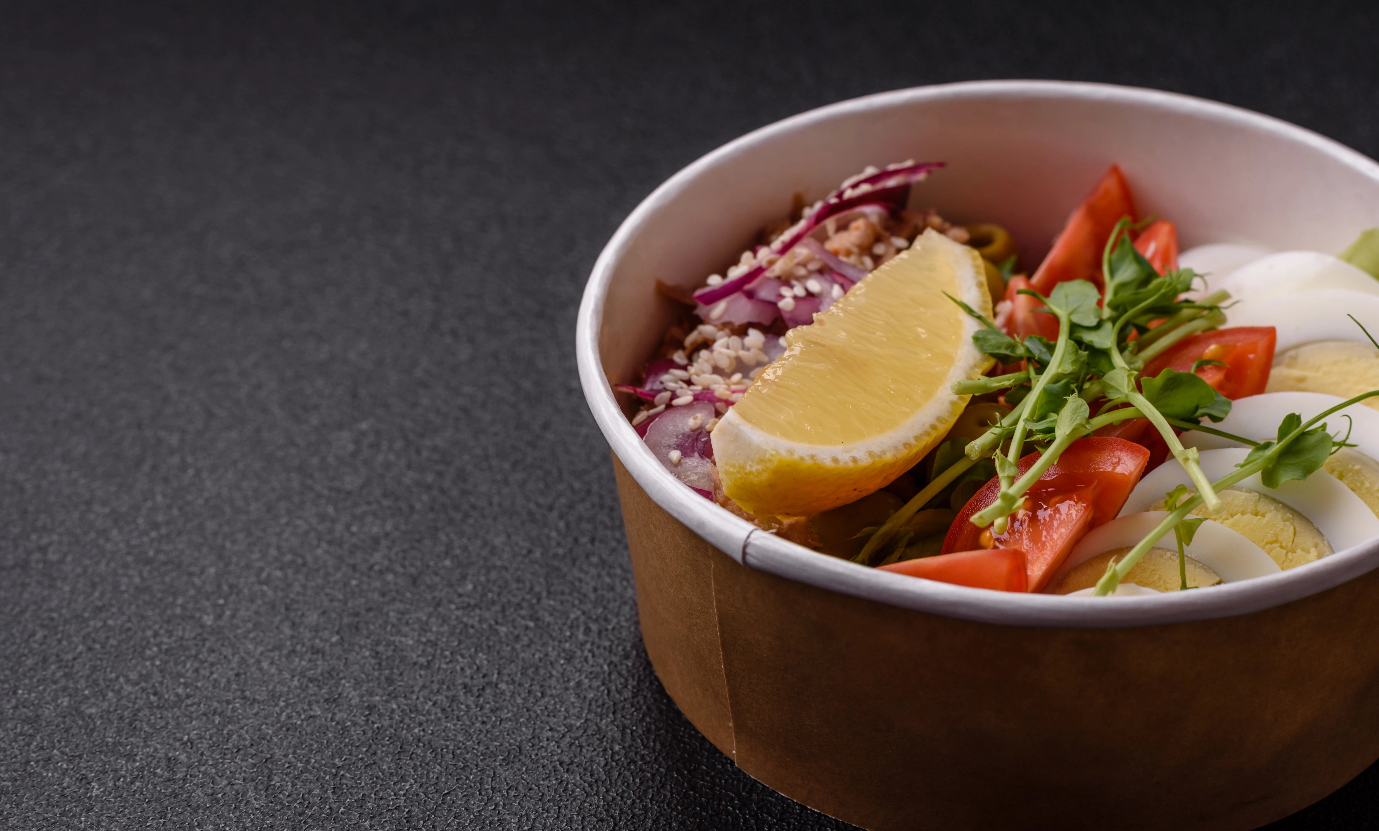 Volle Salatschüssel ohne Deckel in braun und weiß.